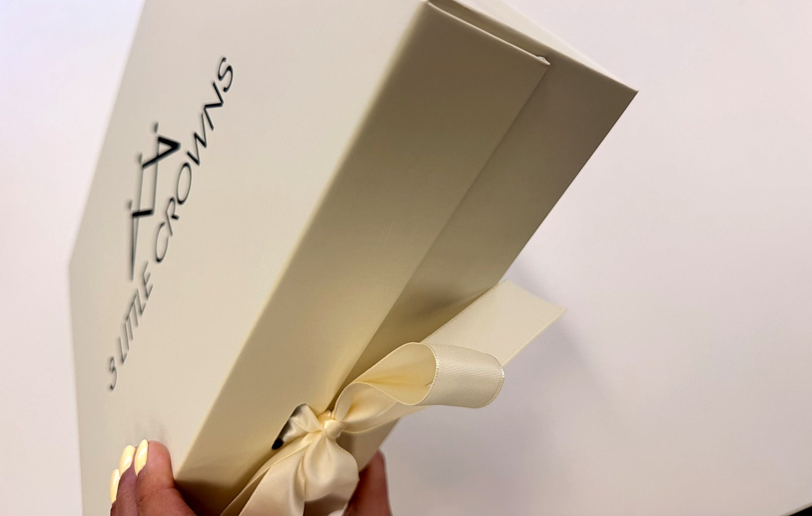 3 Little Crowns gift box held to show full box depth and side branding